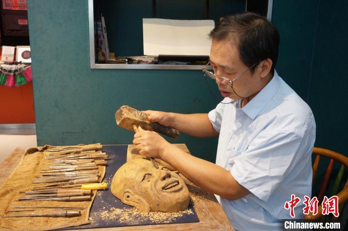 9月6日,桂北傩面具制作技艺代表性传承人唐江峰在雕刻傩面具。 欧惠兰 摄