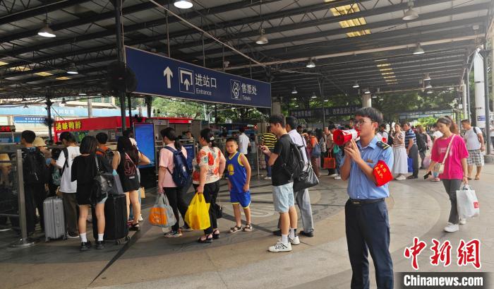 图为南宁车站工作人员引导旅客有序进站。麦竹娴 摄