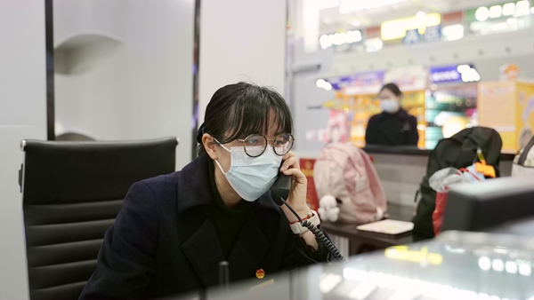 张婷婷在接听旅客电话。李俊鸣摄.jpg