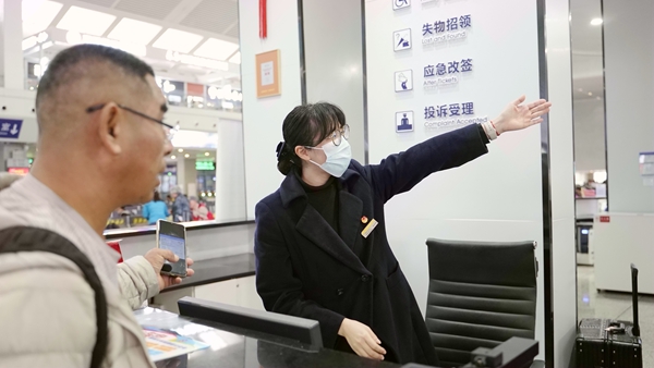 张婷婷为旅客提供引导服务。李俊鸣摄