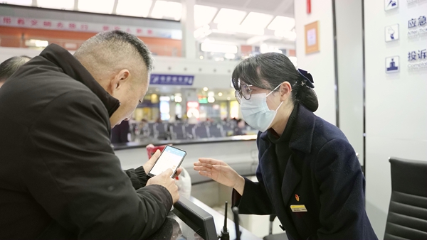 张婷婷在为旅客解答车票咨询问题。李俊鸣摄
