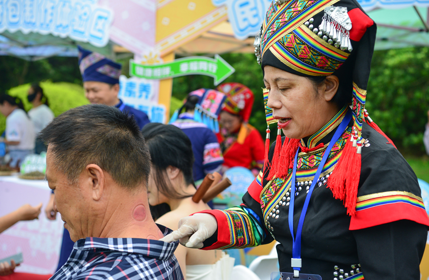 市民朋友体验壮医药物竹罐疗法。