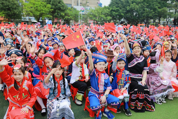 师生们一起挥舞手中的国旗。南宁市云景路小学供图