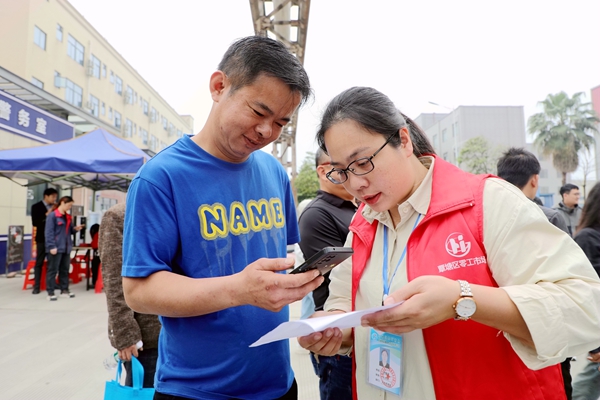 覃塘区零工市场工作人员向求职者推荐线上零公招聘群（李柳慧摄）.jpg