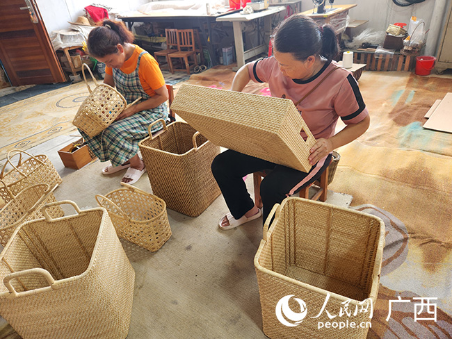 在浦北县丹丹工艺编织专业合作社，工人们正在对产品进行检查。人民网记者 黄子婧摄